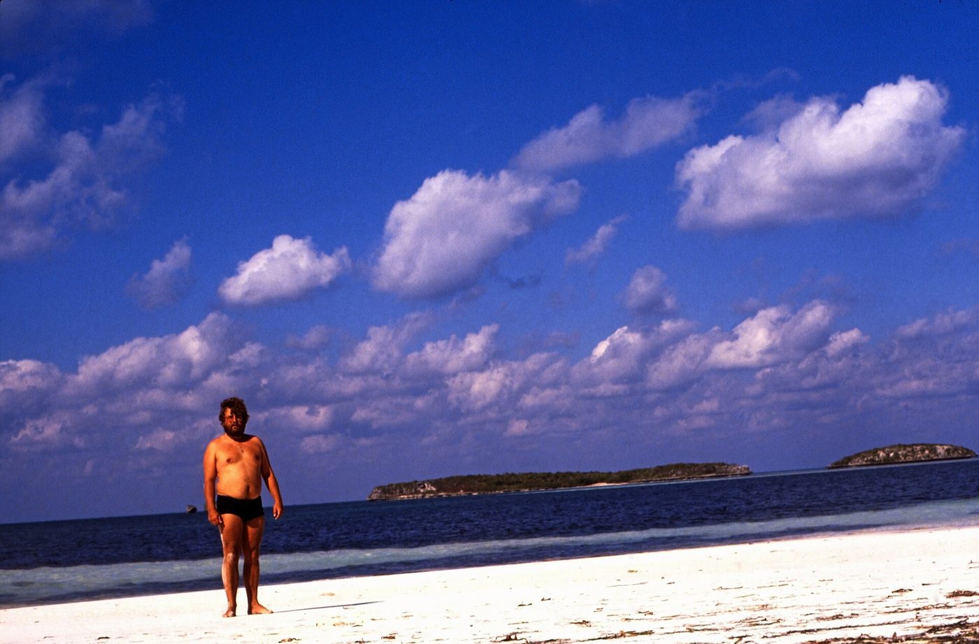 A person standing alone on a white sandbar under a wide sky, Spanish Wells